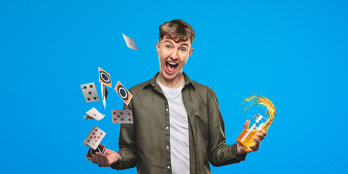 An excited young man throwing playing cards and beer into the air enthusiastically.