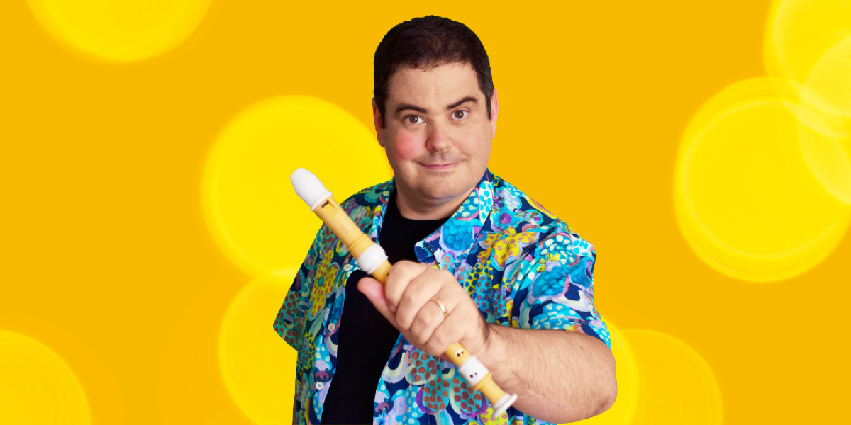 Richard has short dark hair, brown eyes & a bright, colourful shirt. With one eyebrow raised and a half-smile he reaches his left hand holding a recorder towards the camera as if to offer you to have a go.