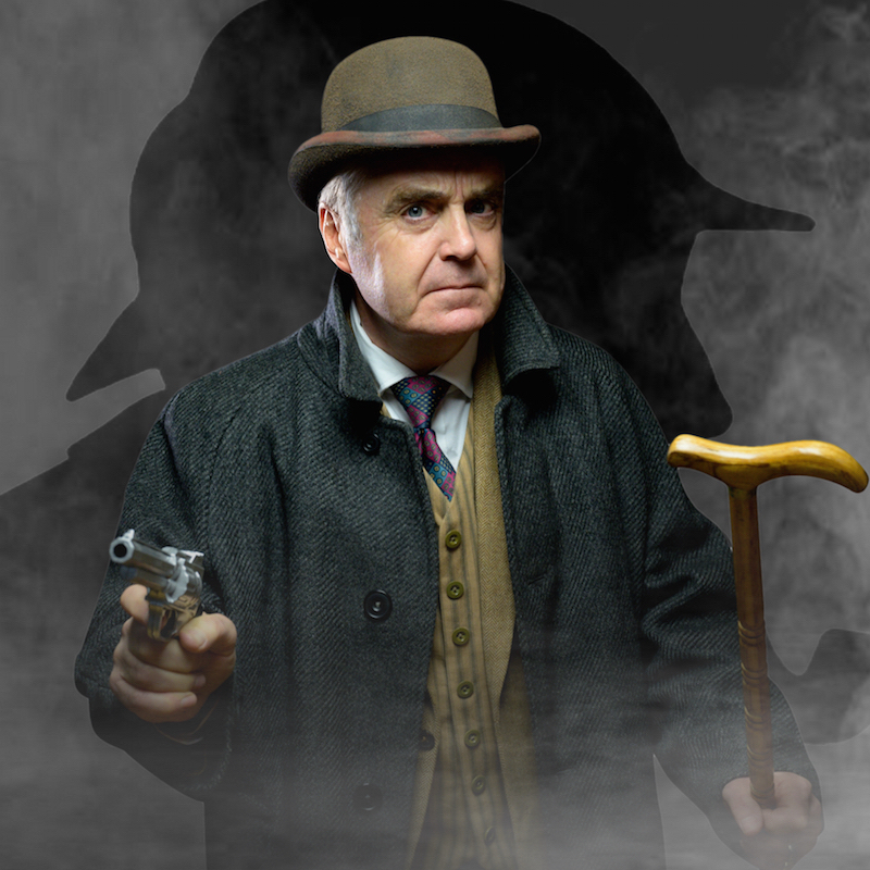 Serious faced man dressed in bowler hat, waistcoat and jacket holding a cane and a gun. 
Sherlock Holmes shadow behind.