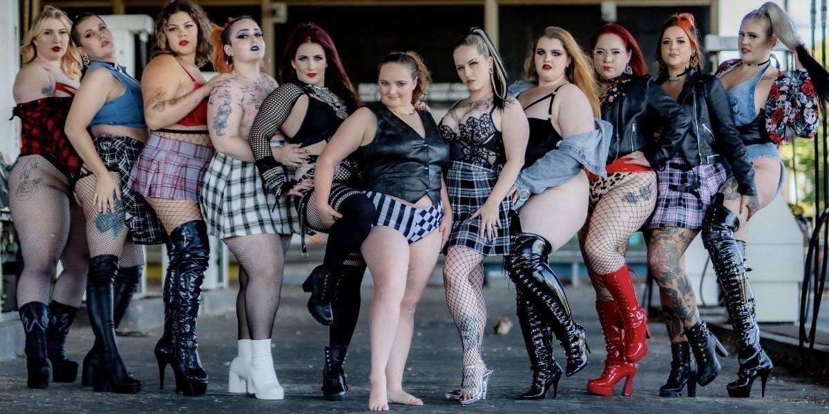 Down with the Thickness - A group of women are posed together in a line wearing grunge punk outfits and high heels