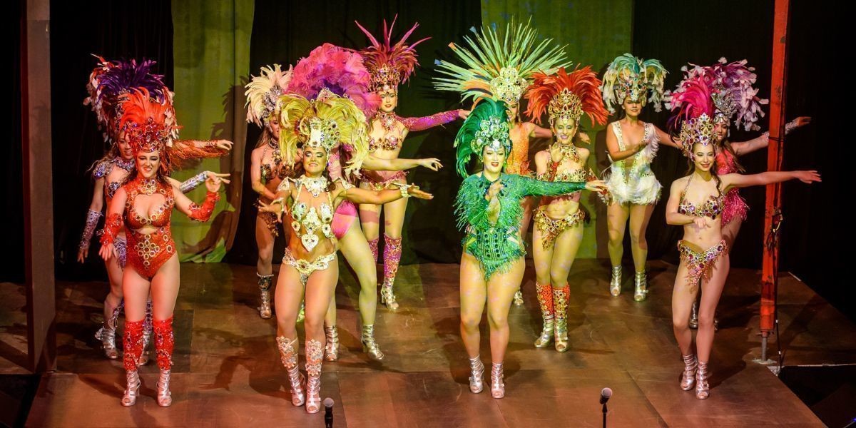 Female samba dancers together on a stage.