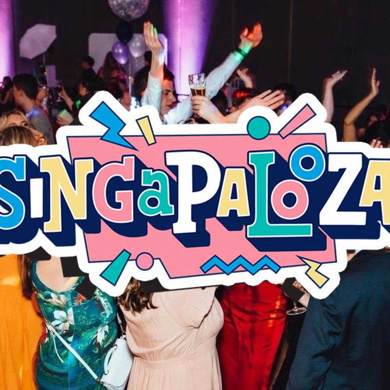 There is a crowd of people dancing, with their hands in the air, looking excited and happy. Across the picture there is text saying "Singapalooza" in a pink, blue, and white font