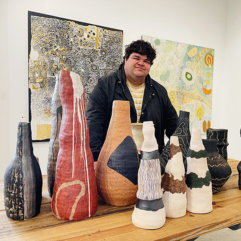 Artist Alfred Lowe in the APY Gallery Adelaide with his ceramic artworks.