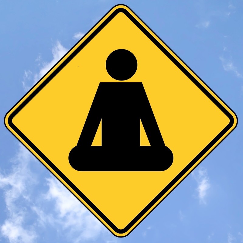 Try Buddhist Meditation - Meditating figure on a sign post