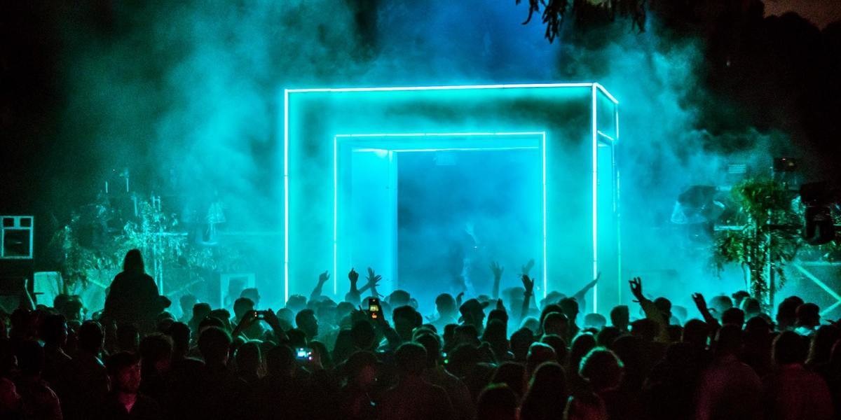 pale blue stage lighting a cube gives eerie lighting in smoke at a night time music festival