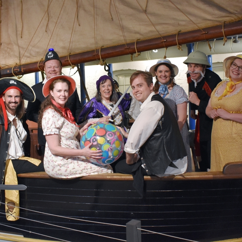 Cast dressed in pirate costume on a ship