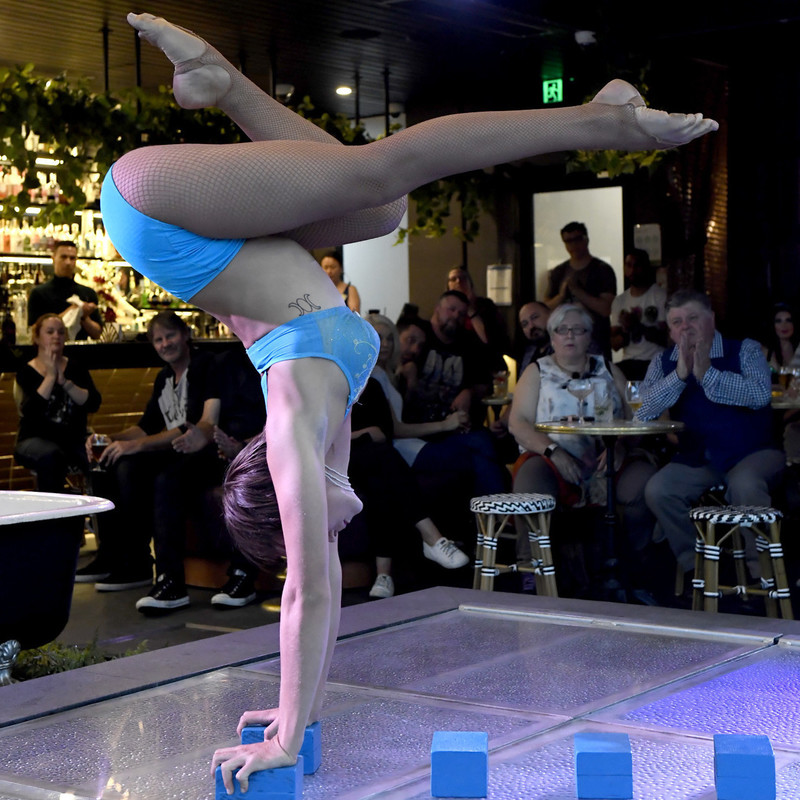 a contortionist in a blue bikini does a handstand