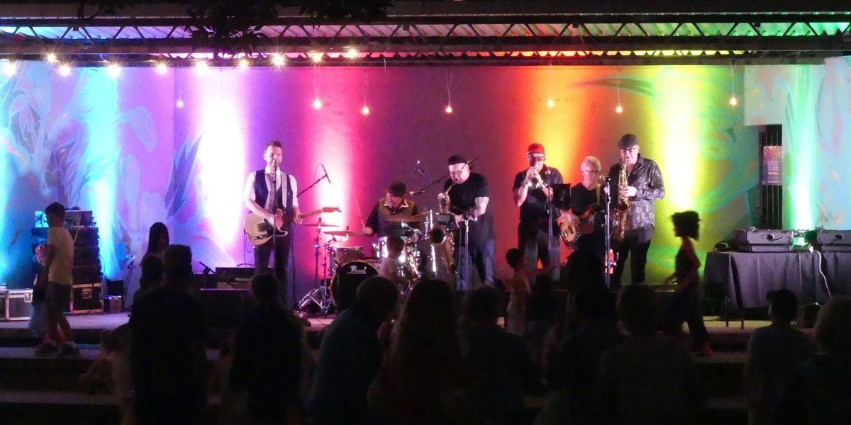 Band playing on stage with colourful lights