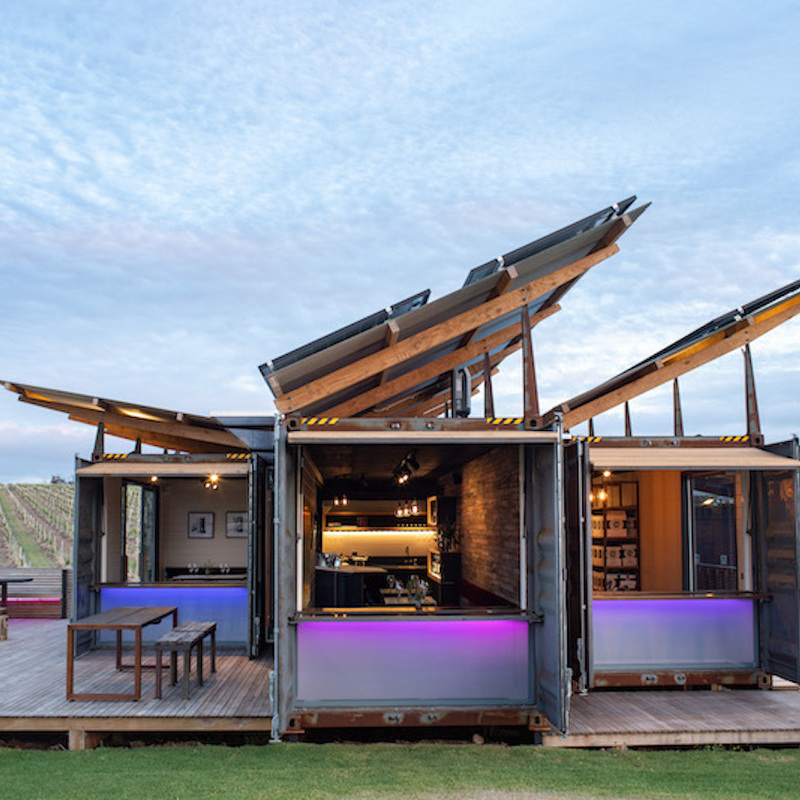 Four shipping containers, architecturally designed and placed in a vineyard, with 360 degree views of vines. Rustic exterior of the shipping containers, with LED lighting panels.