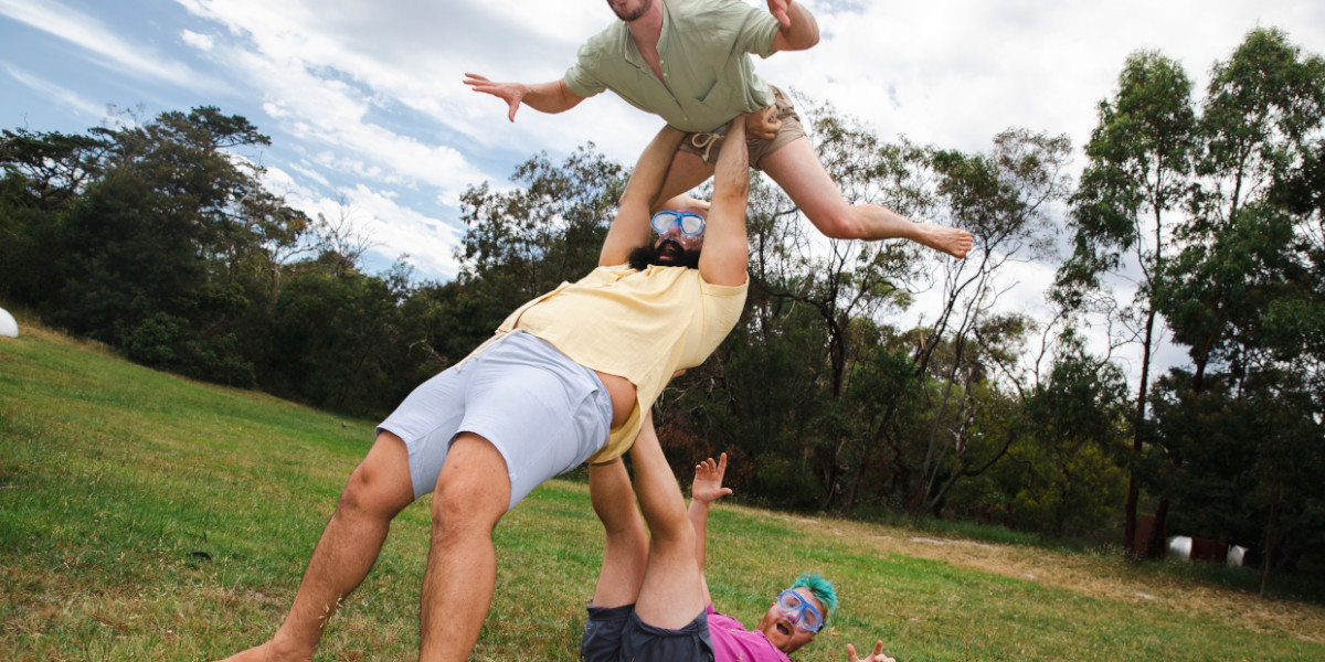 Three performers are creating a human pyramid