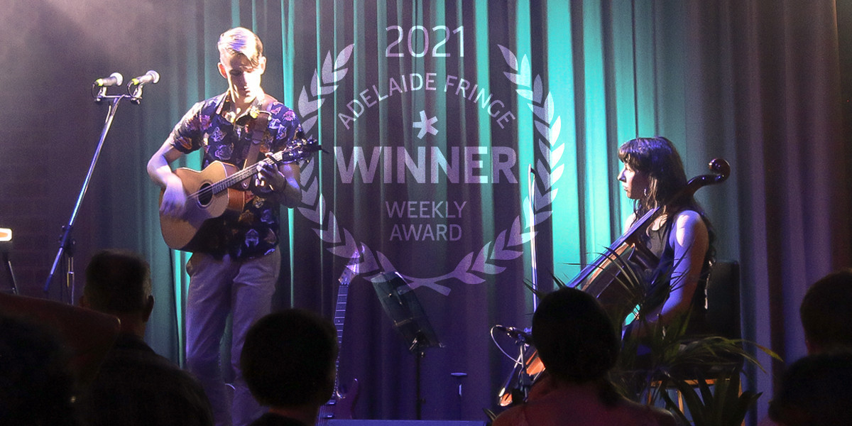 Two musicians stand on a dimly blue-lit stage with rays of light filtering over them. A male guitarist stands on the left looking down at the guitar, a female cellist sits down on the right looking up at the guitarist. Both of their faces are highlighted by the spotlight. A faded emblem is featured in the centre with the words "2021 Adelaide Fringe - Winner - Weekly Awards"