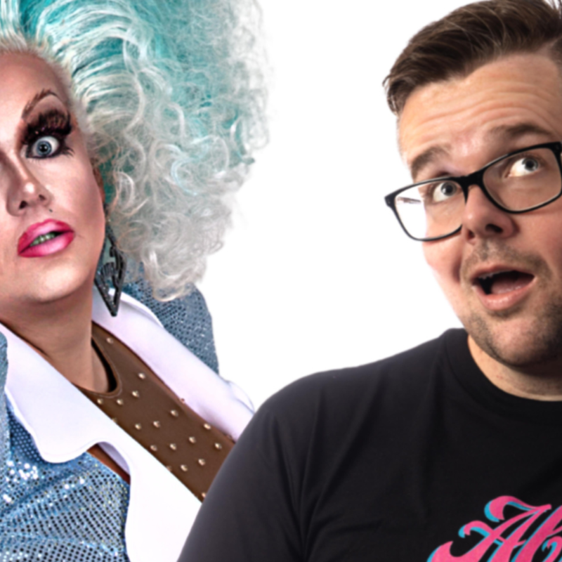 An image of two people. On the left-hand side, is a female-presenting person/drag queen with big light blue curly hair and a blue leotard with puffy sleeves. On the right-hand side is a male presenting person with brown hair, glasses and a blue stiletto heal held to their ear.