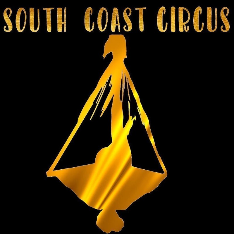 A logo image that reads, ‘South Coast Circus’ in gold decorative font with an outline of a woman hanging upside down holding on to a piece of fabric.