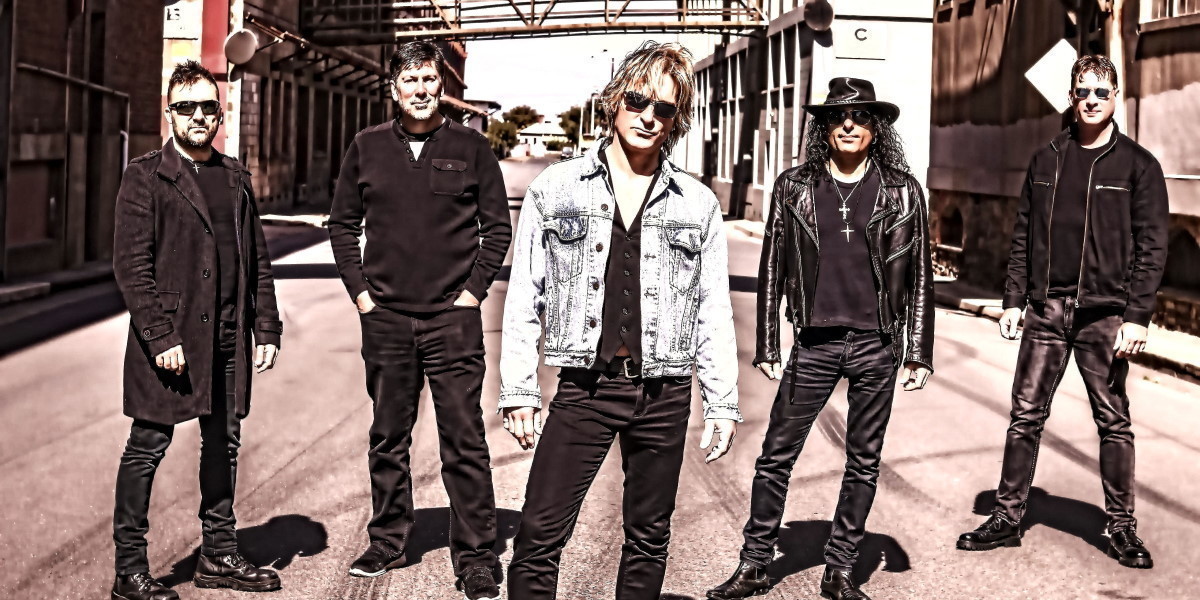 One Wild Night - 5 piece Bon Jovi tribute band featuring Tib Horvath standing in industrial park.