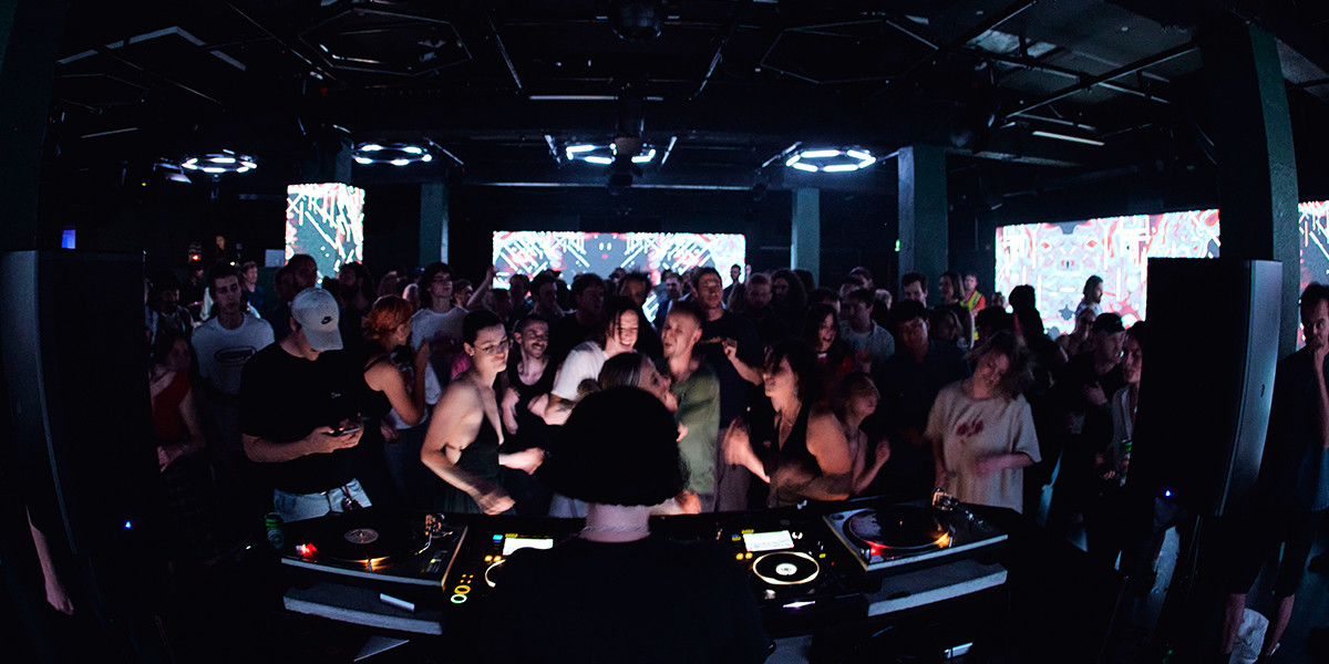 large group of people dancing in a dark club
