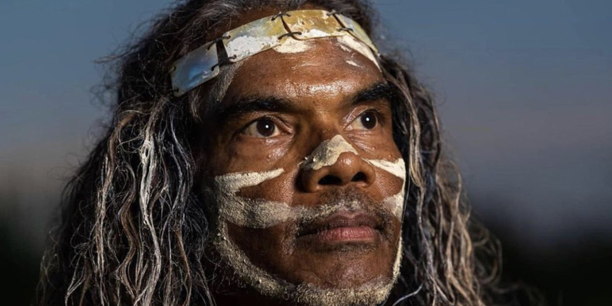 Sean Choolburra with aboriginal traditional face paint pondering the world.
