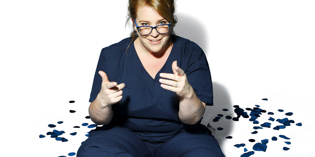 Nurse Georgie Carroll: Sista Flo 2.0 - Georgie Carroll sitting on the floor hands pointed forwards with confetti surrounding her