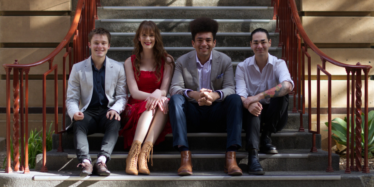 Four performers (Left to Right: Solomon Young, Tiffany Gaze, Jackson Mack and James Ho) sit together on a staircase.