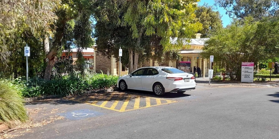 Two designated accessible car park spaces located in the front carpark for Fullarton Park Community Centre with a white vehicle parked in one of the spaces.