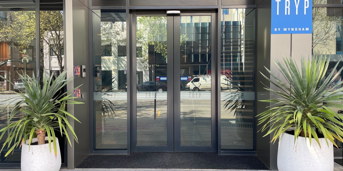 Main entrance of the hotel at 266 Pulteney Street. Showing automatic doors to the hotel and call button for late night access with TRYP by Wyndham signage